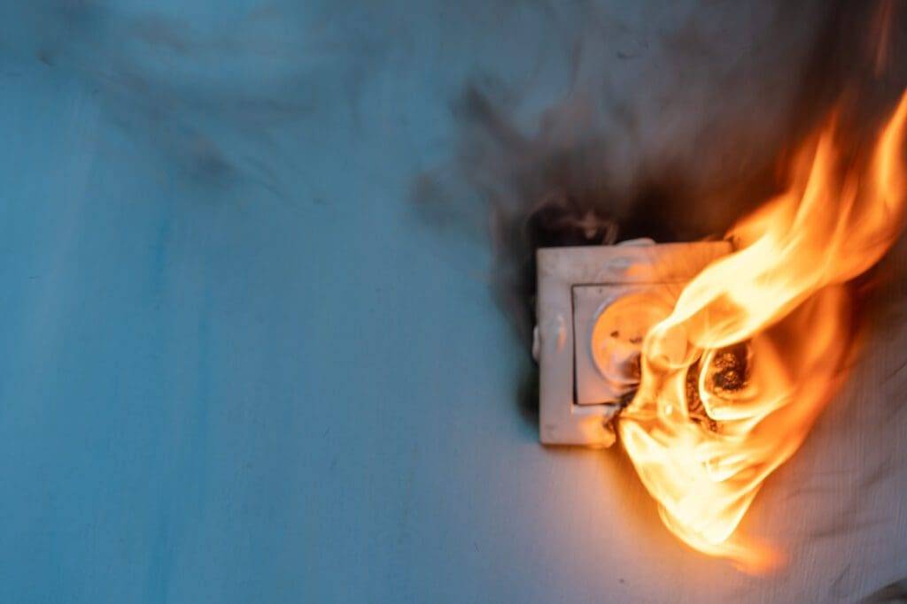 A fire is burning in the middle of an electrical outlet.
