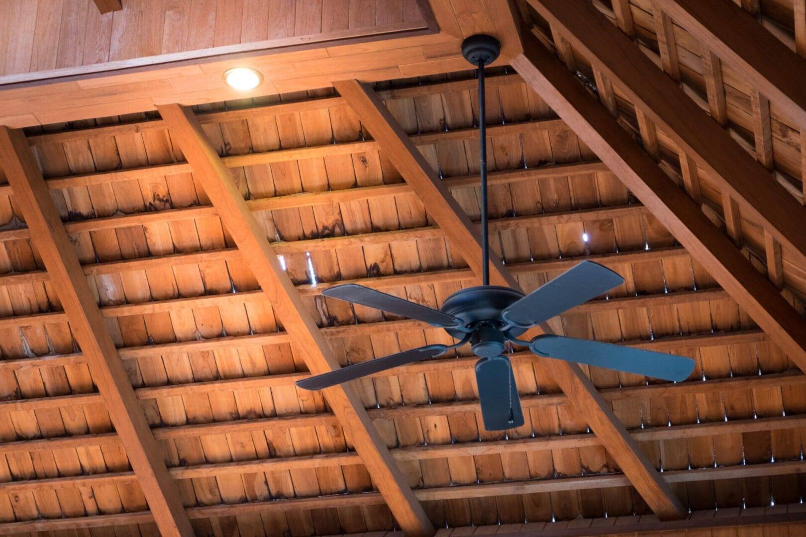A ceiling fan is shown in the middle of an open roof.