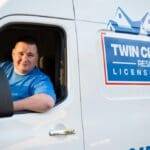 A man sitting in the drivers seat of a truck.