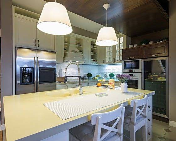 A kitchen with two lights hanging above the island.