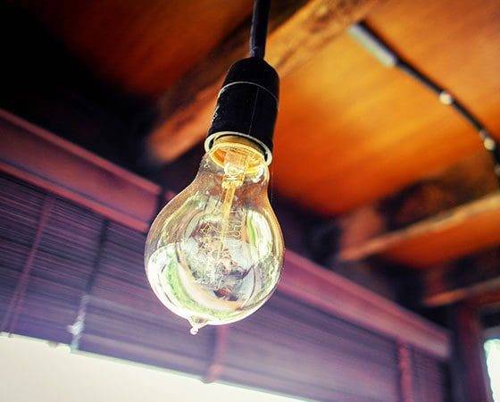 A light bulb hanging from the ceiling of a room.