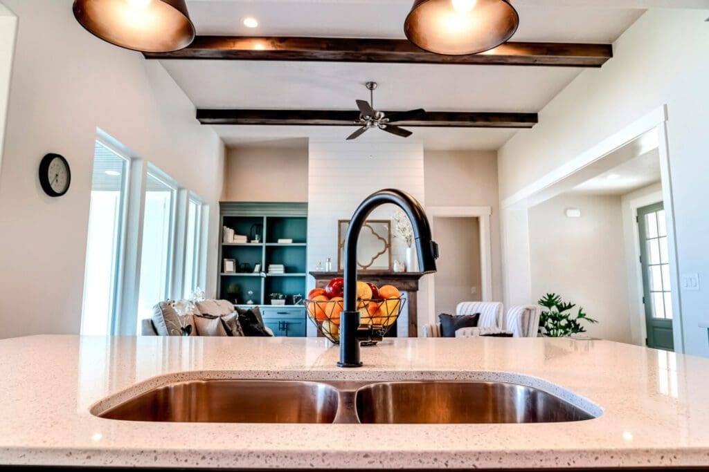 A kitchen sink with a black faucet and white counter.