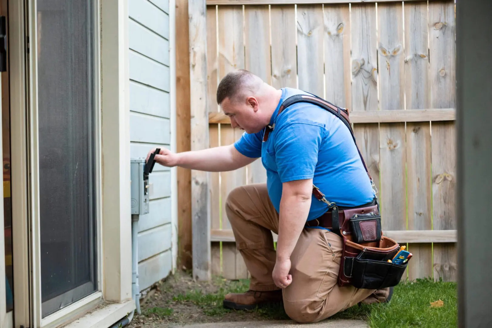 A man in blue shirt fixing a wall.