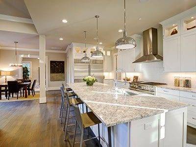 A kitchen with a large island and granite counter tops.