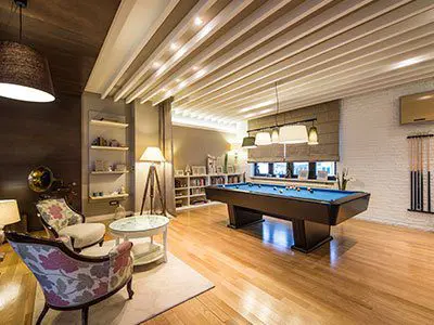 A room with a pool table and chairs