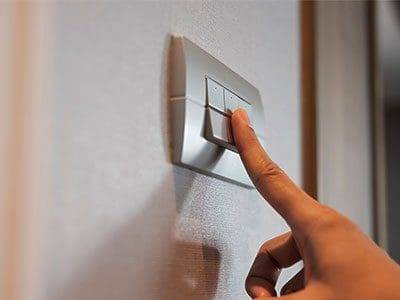 A person is pressing the button on an electrical device.