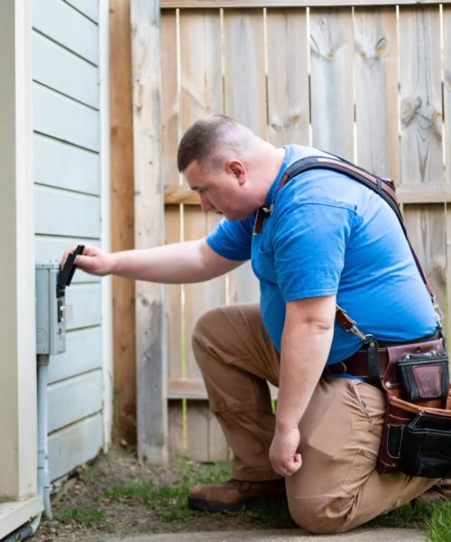 A man in blue shirt fixing a wall.